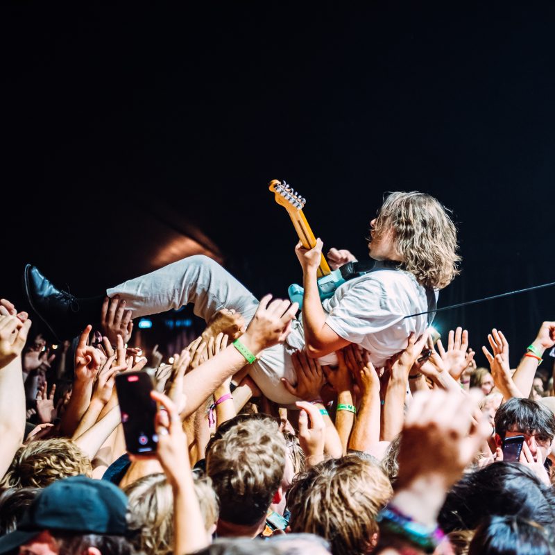IDLES guitarist crowd surfs on a sea of hands at Boardmasters Music Festival 2022. Music Festival Photography by UK Music Photographer Will Bailey