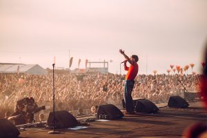 Tom Grennan performing to an energetic crowd at Boardmasters 2023 while the sun sets in Newquay, Cornwall. Music Festival photography by Will Bailey